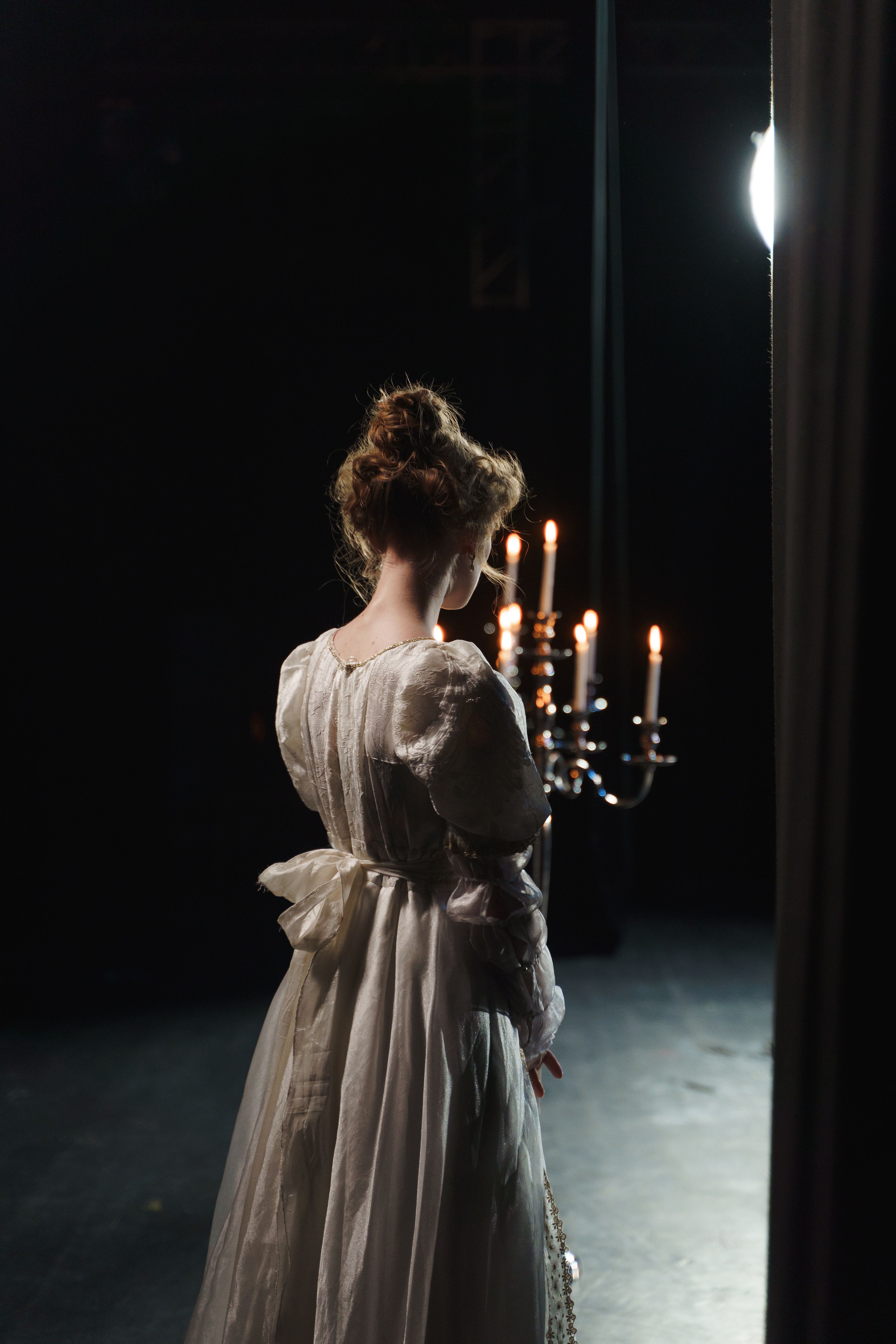 Drama students performing on a modern stage with dramatic lighting